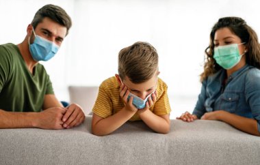 Aile, koronavirüse karşı maske takıyor, kirlilik, hastalık ve evde kalıyor. Virüsü, gribi ve kirliliği önlemek için koruyucu maske takan üzgün aile.