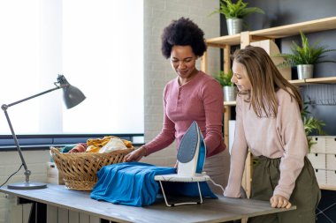 Mutlu evlatlık çocuk siyahi annelere ev işlerini ve ev işlerini birlikte yapmaları için yardım ediyor. Mutlu aile kavramı.