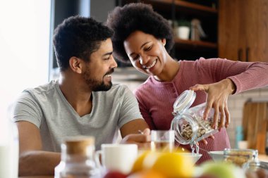 Modern mutfakta taze yemek hazırlarken mutlu genç siyah çift eğleniyor.