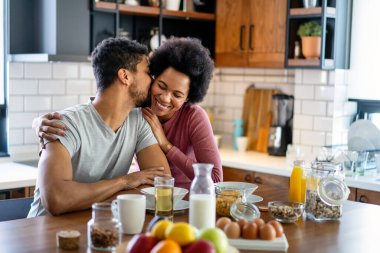 Modern mutfakta taze yemek hazırlarken mutlu genç siyah çift eğleniyor.