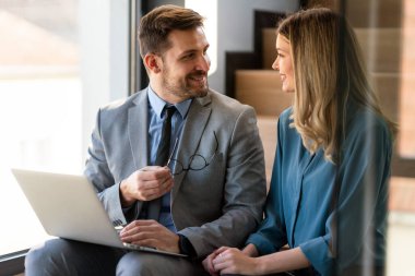 Tam konsantrasyon. Takım olarak çalışan ve kurumsal ofiste iletişim kuran bir grup genç iş adamı.