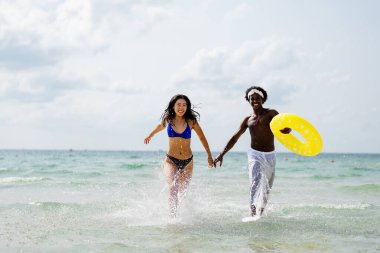 Kaygısız bir çift, tropik bir plaj tatilinde eğleniyor, güneşin altında şişme bir yüzükle gülüyor ve oynuyorlar, birlikte unutulmaz anılar yaratıyorlar.