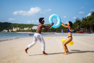 Romantik bir plaj kaçamağının keyfini çıkaran ırklar arası bir çift tropik bir cennette sevgi, kahkaha ve birlikteliği kucaklıyor.