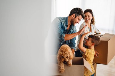 Yeni ev, kutu ve çocuklu aileler, yeni ev kredisi ve gayrimenkul yatırımları. Ev sahibi, taşınma günü için heyecanlı aile, taşınma ve kiralama konsepti