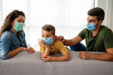 Virüsü, gribi ve kirliliği önlemek için koruyucu maske takan üzgün bir aile. Kirlenmiş hava konseptinden aile koruması