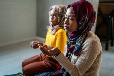 Müslüman anne ve kızı birlikte dua ediyorlar. Dini faaliyet kavramı