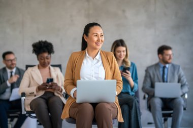 Genç mutlu iş kadını şirket çalışanı masa başında çalışıyor. Gülümseyen kadın profesyonel insan kaynakları müdürü şirket ofisinde bilgisayar kullanıyor.