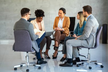 Etkili grup terapisi. Çok ırklı profesyonel insanlar bir araya gelip grup seansı yaparken birbirlerine bakıyorlar.