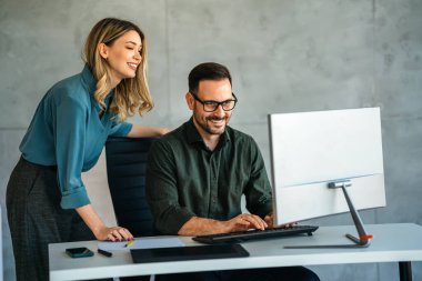 İş projesi ekibi şirket ofisindeki toplantı odasında birlikte çalışıyor.