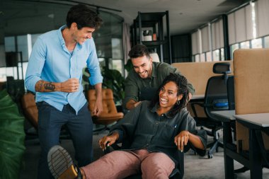 Bin yıllık çok ırklı takım insanlar eğlenmek oda ofis, heyecanlı farklı çalışanlar iş kopma komik faaliyet zevk gülüyor koltuklarda sürme yaratıcı samimi işçiler birlikte oyun oynamak