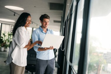 Neşeli çok ırklı meslektaşlar, ofis içi iş günlerinde başlangıç projesini tartışıyor ve gülümsüyor. Mutlu çeşitli başarılı iş arkadaşları yeni bir projede birlikte çalışıyorlar..