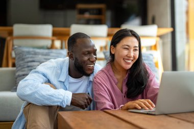 Dijital yaşam tarzı ve çevrimiçi bağlantı. Modern teknoloji odaklı dünyada eğlence, alışveriş ve kusursuz iletişimin tadını çıkaran çok ırklı mutlu bir çift.