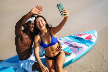 Çeşitli çiftler, arkadaşlar her zaman bağlanır, teknolojiyi ve sosyal medyayı kucaklarlar, dijital çağda çevrimiçi kalarak sahilde kaygısız anların tadını çıkarırlar.