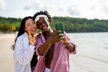 Moda dijital yaratıcısı çift sahilde şık bir selfie çekiyor, sosyal medya için seyahat içeriğini paylaşıyor, cennetteki etkili yaşam tarzını yaşıyorlar.