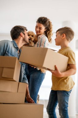 Yeni ev, kutu ve çocuklu aileler, yeni ev kredisi ve gayrimenkul yatırımları. Ev sahibi, taşınma günü için heyecanlı aile, taşınma ve kiralama konsepti
