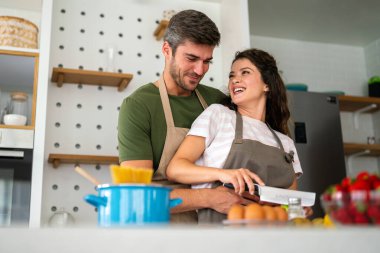 Gizli bileşen aşktır. Güzel genç çift evde boş vakit geçirirken birlikte sağlıklı bir yemek hazırlıyor.