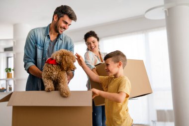 Yeni bir apartmanda kutularla taşınan çocuklu mutlu bir aile. Ev sahibi, taşınma günü için heyecanlı aile, taşınma ve kiralama konsepti