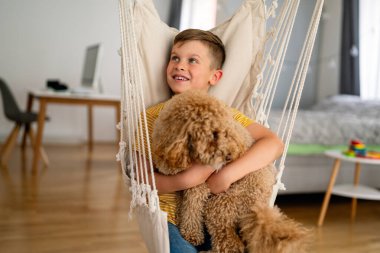 Mutlu çocuk yeni evcil arkadaşına sarılıyor, evlat edinilmiş küçük köpeğine. Hayvan dostluğu. İnsanlar mutluluk konseptini severler.
