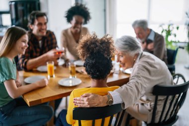 Karı, koca, çocuklar, büyükbaba ve büyükanneyle birlikte yemek yerken çok ırklı mutlu olun.