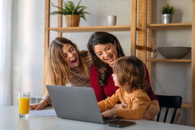Evde çalışan birden fazla bekar anne. Anneler iş ve aileyi dengeleyebilir... aile dizüstü bilgisayarla çalışır ve evde birlikte eğlenir..