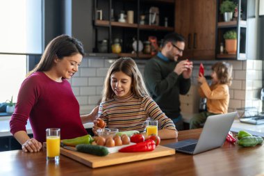 Mutlu bir aile mutfakta eğleniyor, hafta sonları birlikte güzel vakit geçiriyorlar. Aile, mutluluk konsepti