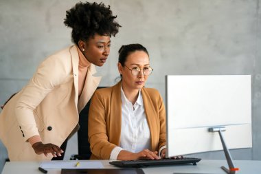 Modern ofisteki bilgisayarlarına bakan yaratıcı bir ekip. Tasarımcı, banka müdürü ve avukatlık bürosunda birlikte çalışan başarılı kadınlar..