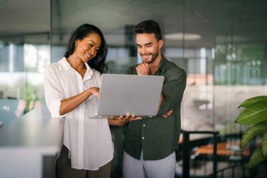 Ofisteki dijital cihazları kullanarak gülümseyen bir yönetici ekibi. Çeşitli profesyonel liderler yöneticiler ve çalışanlar takım çalışmasında çalışan dijital finans projesini tartışıyor.