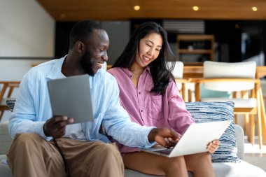 İş ekibi, iki mutlu çeşitlilik, çok ırklı yönetici ofiste dizüstü bilgisayar kullanarak birlikte çalışıyorlar. Genç iş kadını yöneticisi iş toplantısında sunum yapıyor, danışmanlık yapıyor.