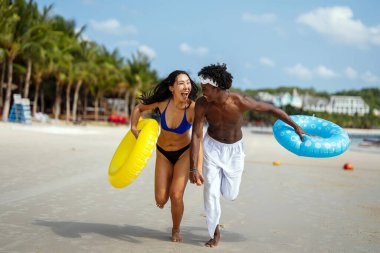 Tasasız yaz macerası. Genç, ırklar arası bir çift, güvenli seyahat sigortası ile güvence altına alınmış, tropikal tatillerinin keyfini çıkarıyorlar.