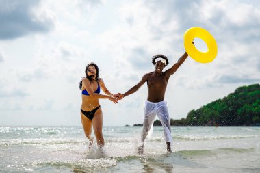 Romantik bir plaj kaçamağının keyfini çıkaran ırklar arası bir çift tropik bir cennette sevgi, kahkaha ve birlikteliği kucaklıyor.