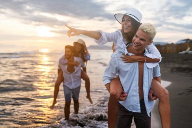 Çeşitli arkadaşlar güneşli bir sahilde canlı bir yarışın tadını çıkarırlar. Açık hava, deniz kenarındaki yaz etkinliklerinin neşesini yakalar..