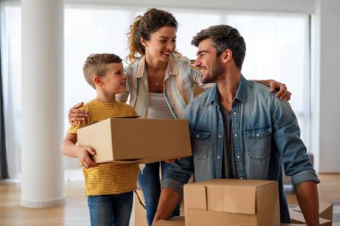 Taşınmak, ebeveynler ve çocuklar yeni evde aile zamanı için bir araya geliyorlar. Mutlu aile, ipotek ve ev için karton kutular açmak.