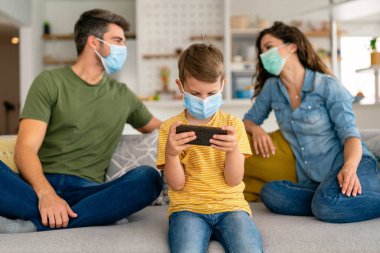 Virüsü, gribi ve kirliliği önlemek için koruyucu maske takan üzgün bir aile. Kirlenmiş hava konseptinden aile koruması