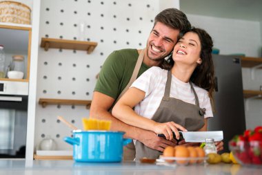 Genç mutlu çift evlerinde, mutfakta birlikte sağlıklı bir yemek hazırlıyorlar. Sağlıklı yaşam tarzı, kaliteli zaman, mutluluk, insan kavramı