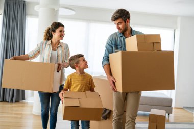 Küçük oğlu olan mutlu beyaz bir aile yeni bir eve ya da daireye taşınırken eğleniyor. Gülümseyen adam ve kadın, kendi evine taşınan çocukla bavullarını boşaltmaktan zevk alır. Kira, ipotek kavramı