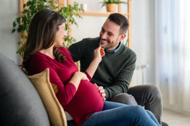 Aşk, şefkat, ilişki ve yeni aile kavramı. Aşık bir adam hamile karısına sarılır, birlikte bebeklerin gelmesini beklerler.