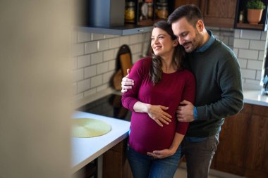 Aşk, şefkat, ilişki ve yeni aile kavramı. Aşık bir adam hamile karısına sarılır, birlikte bebeklerin gelmesini beklerler.