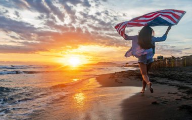 Mutlu kadın gülümseyip plajda koşarken bağımsızlık gününü kutluyor ve Amerika 'da özgürlüğün tadını çıkarıyor.