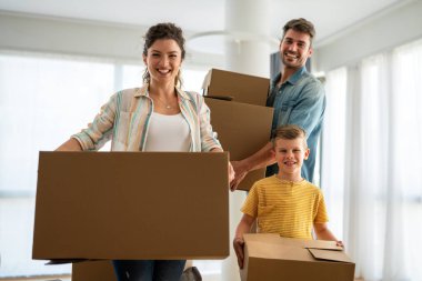 Yeni ev, kutu ve çocuklu aileler, yeni ev kredisi ve gayrimenkul yatırımları. Ev sahibi, taşınma günü için heyecanlı aile, taşınma ve kiralama konsepti