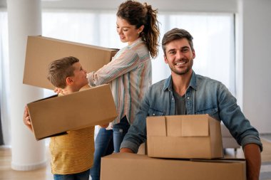 Yeni ev, kutu ve çocuklu aileler, yeni ev kredisi ve gayrimenkul yatırımları. Ev sahibi, taşınma günü için heyecanlı aile, taşınma ve kiralama konsepti