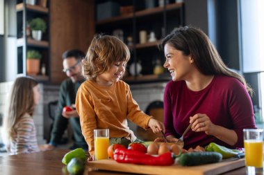 Mutlu bir aile mutfakta eğleniyor, hafta sonları birlikte güzel vakit geçiriyorlar. Aile, mutluluk konsepti