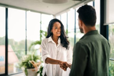 Ofis toplantısındaki mutlu genç iş kadını ve iş adamı tokalaşması. Kadın HR banka müdürü, mali danışman tokalaşan acemi, müşteriyi selamlayan. İş görüşmesinde işe almak, ortaklık kavramı