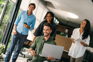 Ofisteki dijital cihazları kullanarak gülümseyen bir yönetici ekibi. Çeşitli profesyonel liderler yöneticiler ve çalışanlar takım çalışmasında çalışan dijital finans projesini tartışıyor.