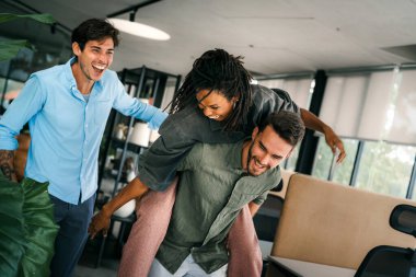 Coşkulu, çeşitli, etnik çeşitlilikte genç meslektaşlar ortak kurumsal başarıyı ya da hedef başarısını kutluyor, modern ofiste kaygısız parti zamanlarının tadını çıkarıyor.