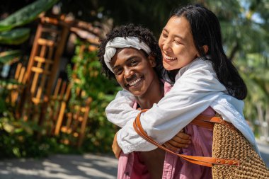 Mutlu çift kumsalda eğleniyor, romantik bir ortamda birlikte gülüyor, aşklarını güçlendiriyor ve güneşin tadını çıkarıyor.