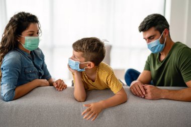 Virüsü, gribi ve kirliliği önlemek için koruyucu maske takan üzgün bir aile. Kirlenmiş hava konseptinden aile koruması