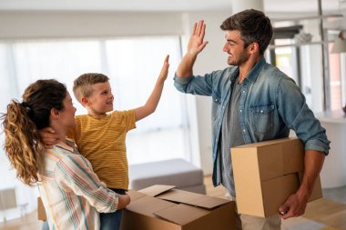 Yeni ev, kutu ve çocuklu aileler, yeni ev kredisi ve gayrimenkul yatırımları. Ev sahibi, taşınma günü için heyecanlı aile, taşınma ve kiralama konsepti