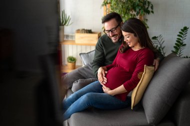 Aşk, şefkat, ilişki ve yeni aile kavramı. Aşık bir adam hamile karısına sarılır, birlikte bebeklerin gelmesini beklerler.