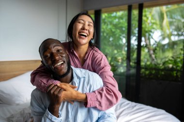 Mutlu çok ırklı çift, sevgi ve kucaklaşma birlikte vakit geçirdikleri için neşeli bir mutluluk içinde gülüyorlar. Çeşitlilik, mutluluk insanları sevme kavramı