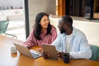 Dijital yaşam tarzı ve çevrimiçi bağlantı. Modern teknoloji odaklı dünyada eğlence, alışveriş ve kusursuz iletişimin tadını çıkaran çok ırklı mutlu bir çift.